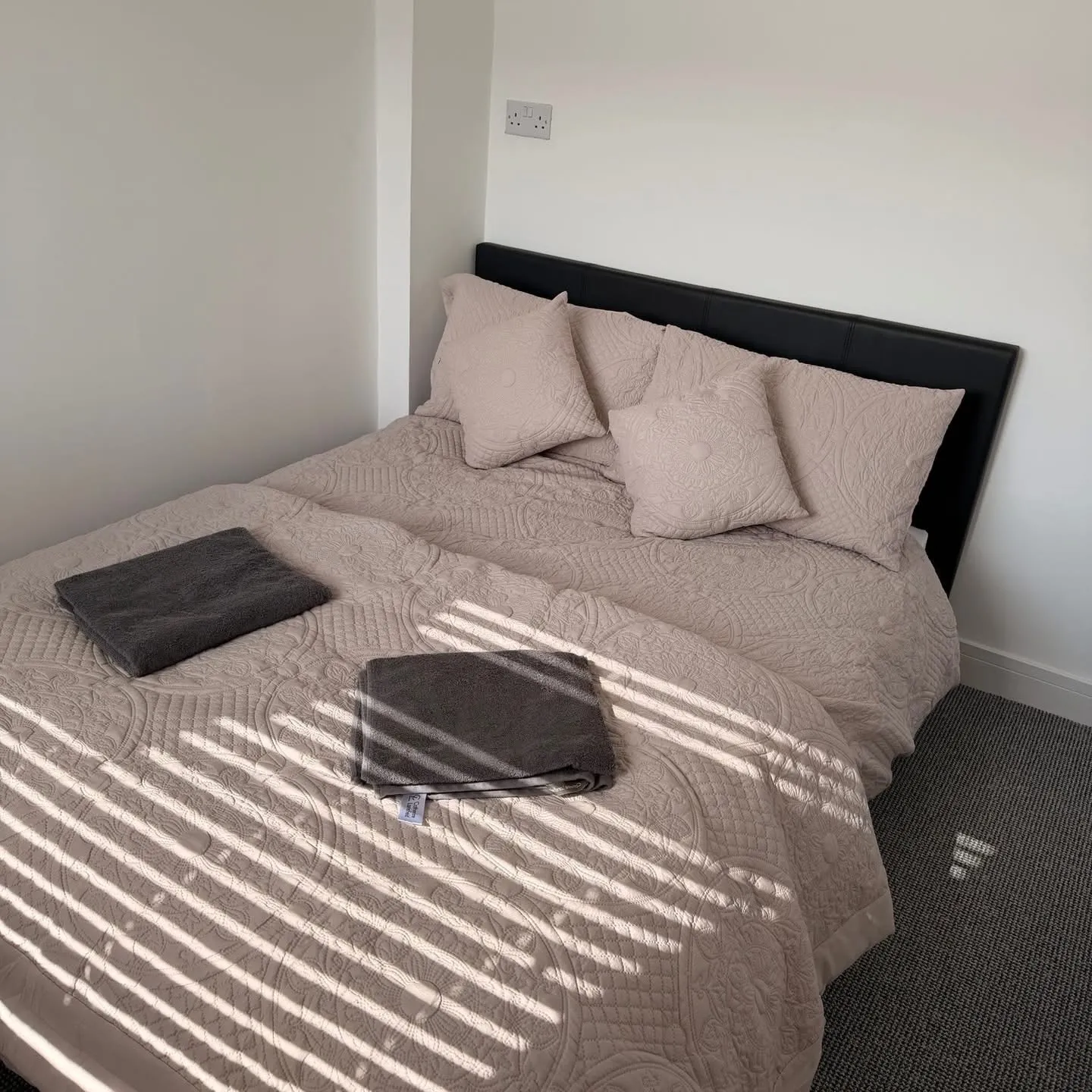 Sunlit double bed with towels at Yaverland Breeze