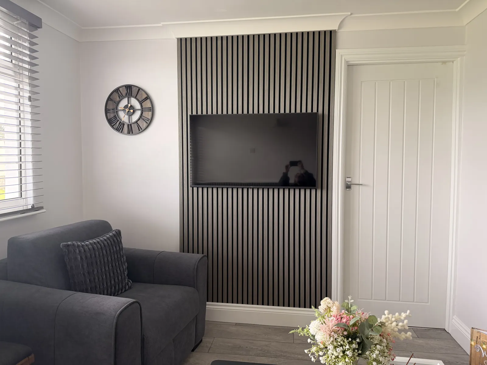 Lounge corner with armchair and wall-mounted TV at Yaverland Breeze